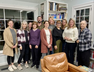 11 people standing in front of bookshelves